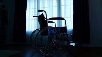 Silhouette von Krankenhaus Rollstuhl im dunkel Zimmer zum Menschen mit Mobilität Behinderung. video