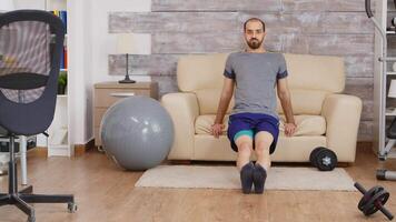 em forma cara Treinamento tríceps em sofá às casa vestindo roupa de esporte. video