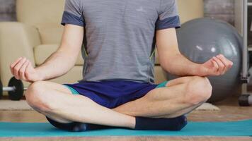 Guy doing yoga at home keeping his eyes closed breathing slowly. video