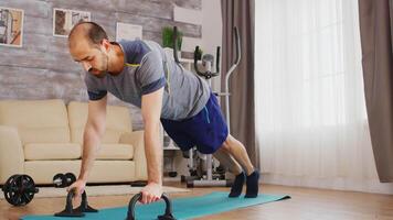 Energetic man doing chest workout on yoga mat at home. video