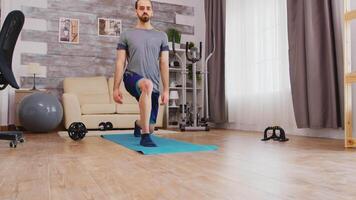 ajuste hombre formación su piernas haciendo adelante estocadas en yoga estera a hogar. video