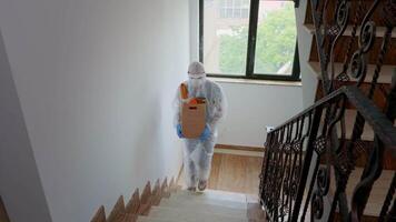 Volunteer carry grocery wearing hazmat suit and gloves against covid-19. video