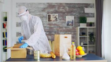 Volunteer organising food wearing protective suit during covid pandemic. video