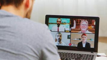 uomo su un' video chiamata con opera colleghi durante se stesso isolamento.