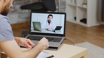 uomo ascoltando medico consigli su video chiamata durante globale isolamento.