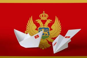 Montenegro flag depicted on paper origami airplane and boat. Handmade arts concept photo