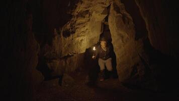 Mens Holding een brandend zaklamp verkennen Woud grot landschap in donker nacht video