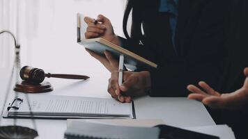 Justice and Law concept. Legal counsel presents to the client a signed contract with gavel and legal law or legal having team meeting at law firm in background video