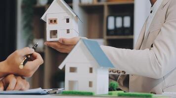 Discussion with a real estate agent, House model with agent and customer discussing for the contract to buy, get insurance or loan real estate or property. video
