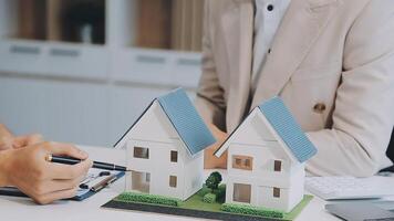 discussion avec un agent immobilier, modèle de maison avec agent et client discutant du contrat d'achat, d'assurance ou de prêt immobilier ou immobilier. video