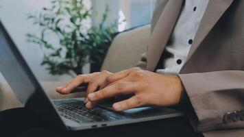 avvicinamento Immagine di un' attività commerciale donna di mani Lavorando e digitando su il computer portatile tastiera su bicchiere tavolo video