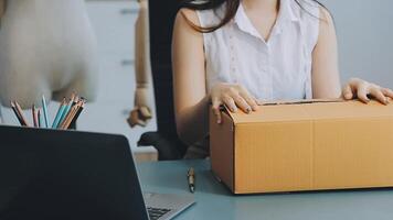 mujer joven propietaria de una pequeña empresa que trabaja en la oficina en casa. entrega de empaques de marketing en línea, empresaria de pymes emergentes o concepto de mujer independiente. propietario de una pequeña empresa video