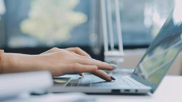 Closeup image of a business woman's hands working and typing on laptop keyboard on glass table video