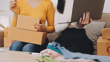 Envío de compras en línea, joven emprendedor de pequeña empresa escribiendo la dirección en una caja de cartón en el lugar de trabajo. video