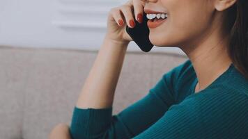 sonriente mujer de negocios utilizando teléfono en oficina. pequeño negocio empresario mirando a su móvil teléfono y sonriente. video