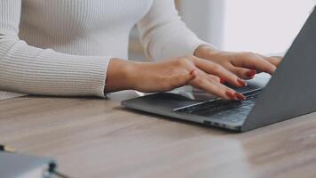 fechar-se imagem do uma o negócio mulher mãos trabalhando e digitando em computador portátil teclado em vidro mesa video