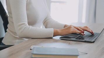 Closeup image of a business woman's hands working and typing on laptop keyboard on glass table video