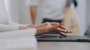 Closeup image of a business woman's hands working and typing on laptop keyboard on glass table video