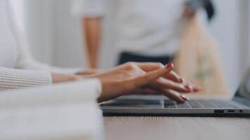 Closeup image of a business woman's hands working and typing on laptop keyboard on glass table video