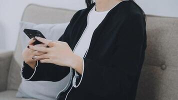 Smiling businesswoman using phone in office. Small business entrepreneur looking at her mobile phone and smiling. video