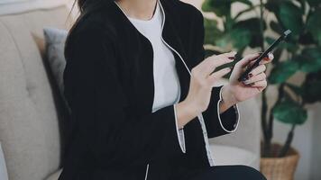 Smiling businesswoman using phone in office. Small business entrepreneur looking at her mobile phone and smiling. video