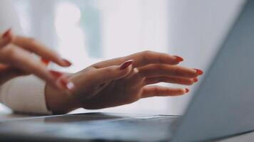 avvicinamento Immagine di un' attività commerciale donna di mani Lavorando e digitando su il computer portatile tastiera su bicchiere tavolo video