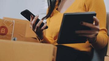 Envío de compras en línea, joven emprendedor de pequeña empresa escribiendo la dirección en una caja de cartón en el lugar de trabajo. video