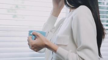 Smiling businesswoman using phone in office. Small business entrepreneur looking at her mobile phone and smiling. video