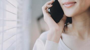 Smiling businesswoman using phone in office. Small business entrepreneur looking at her mobile phone and smiling. video