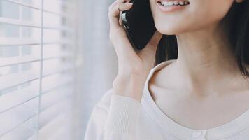 Smiling businesswoman using phone in office. Small business entrepreneur looking at her mobile phone and smiling. video