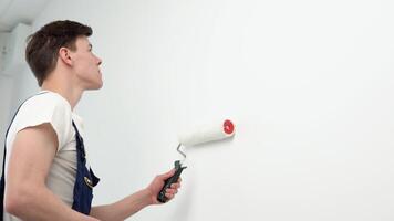 The painter paints the white walls with a paint roller video