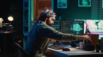 Engineer with EEG headset inserting cartridge into PC to use high tech software allowing for brain transfer into virtual world. Man putting disk in computer to start consciousness upload, camera A video