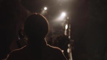 Girl with glasses as part of a tour group inspects a cave video