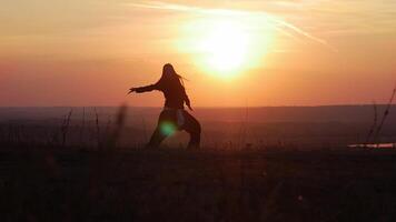 une fille dansant à le coucher du soleil parmi le collines video