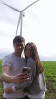 A couple in love is photographed against the background of a wind turbine video