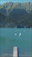 toeristen zeil catamarans Aan een berg meer in de buurt de pier video