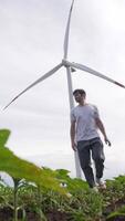 A young guy shoots a blog against the background of a wind turbine. video