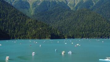 touristes voile catamarans sur Lac ritsa contre le Contexte de montagnes video