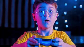 Garoto com óculos é entusiasticamente jogando uma vídeo jogos console video