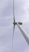 de messen van de wind turbine spinnen tegen een Doorzichtig blauw lucht. video