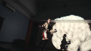 Dancer in spotlight with dramatic shadow on stage video