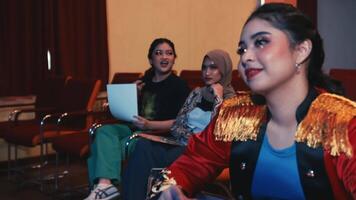 Smiling woman enjoying a show in a theater with audience in the background. video