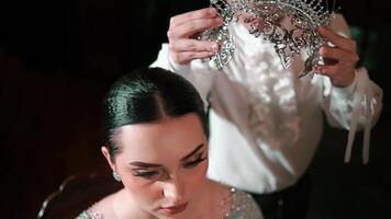 Elegant woman being crowned with a luxurious tiara, symbolizing achievement or royalty. video