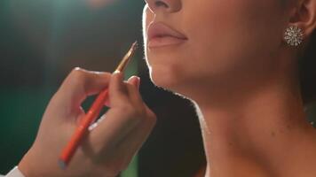 närbild av en kvinna applicering läppstift med fokus på henne mun, skönhet och smink begrepp video