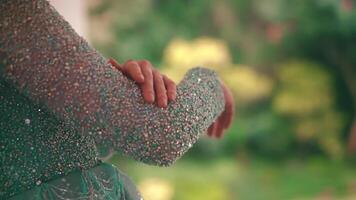 Close-up of a person's glitter-covered arm with a blurred background. video