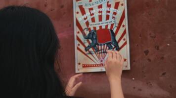 Child playing a bean bag toss game at a carnival, aiming for the target. video