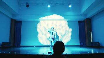 Elegant female dancer with a joyful pose in spotlight, dark background, artistic shadows. video