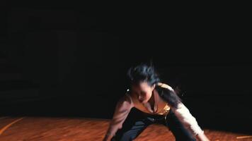 contemporain Danseur dans une dynamique pose sur une foncé organiser, projecteur effet, exprimer émotion par mouvement. video