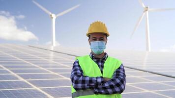 joven ingeniero trabajando para alternativa energía con viento turbina y solar panel - innovación y verde poder concepto video