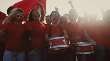 multitud fútbol americano aficionados exultante mientras acecho fútbol juego a estadio - personas con pintado cara y tambor alentador su equipo - deporte entretenimiento concepto video